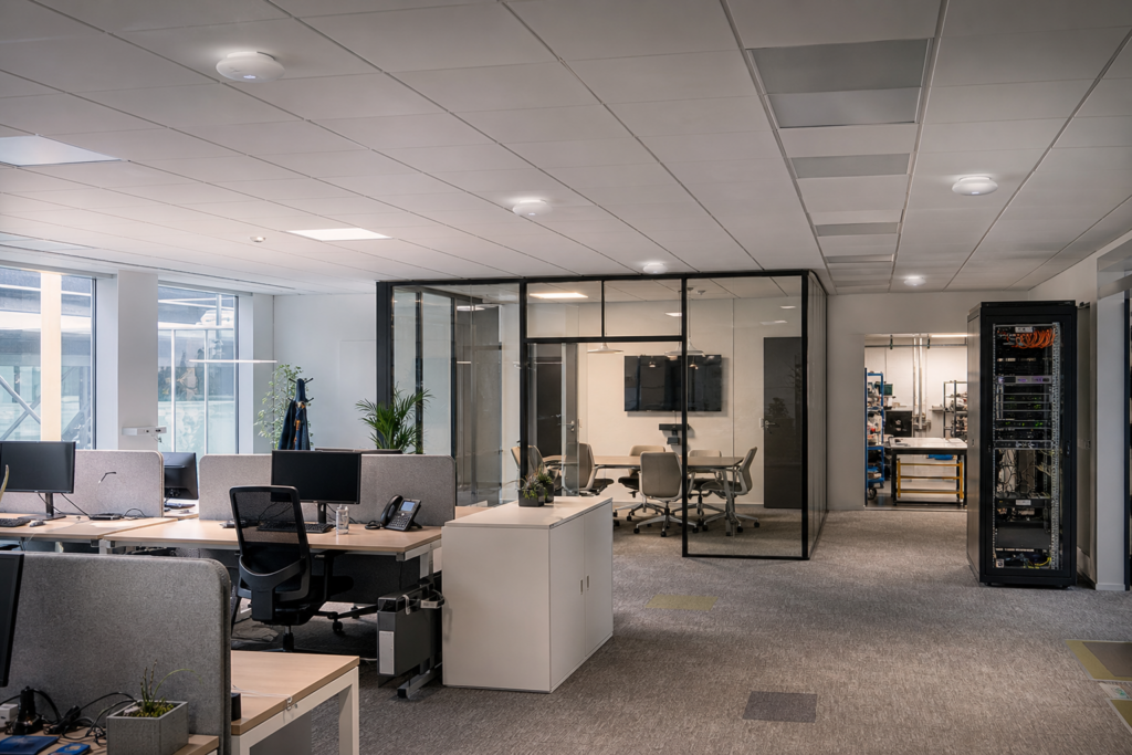 Infrastructure WiFi professionnelle en PME avec bureaux, salle de réunion et zone technique illustrant les causes invisibles d’un réseau lent, instable ou saturé